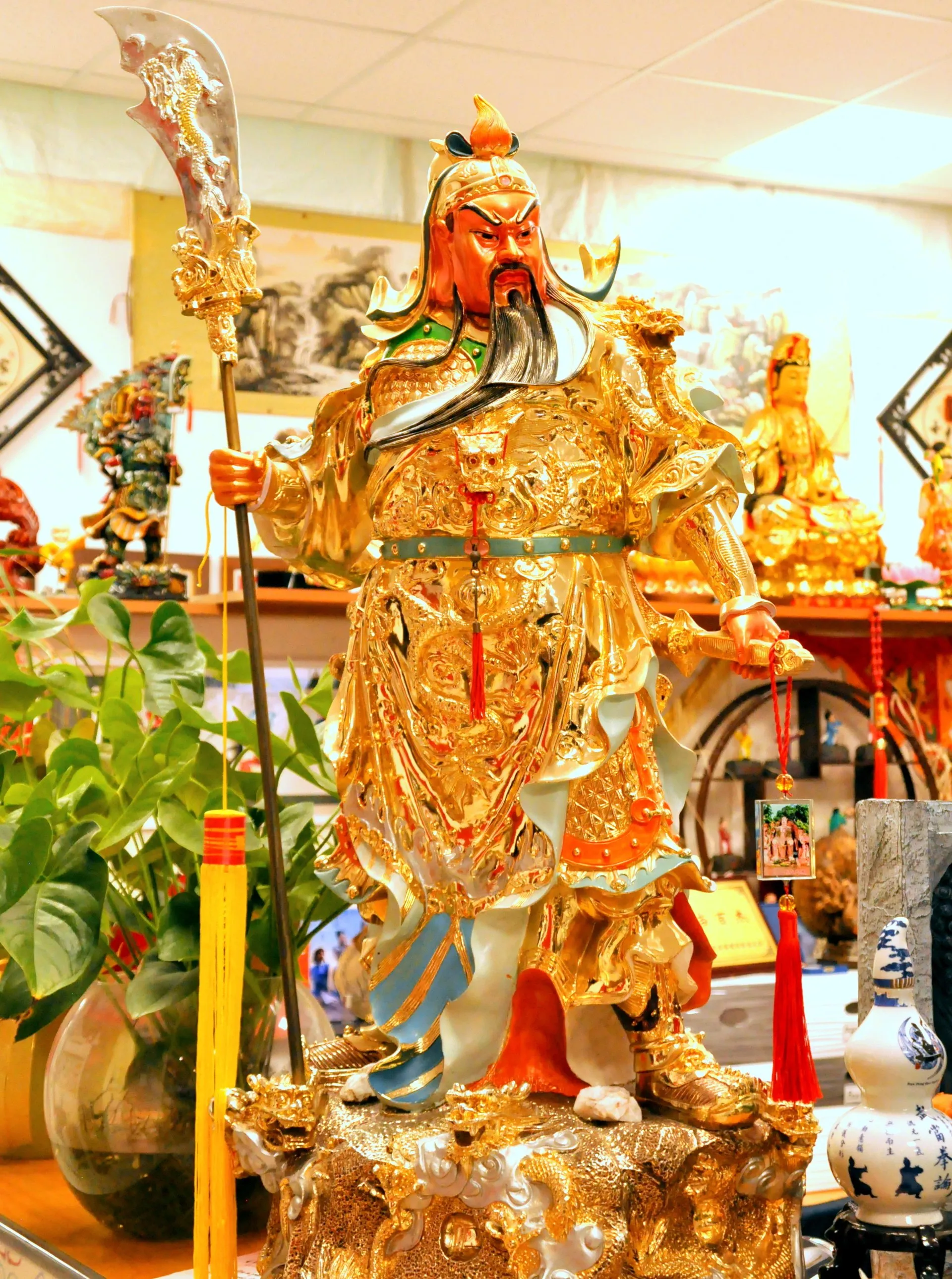 Statua dorata di Guan Yu con piante e offerte nella sala dell'Accademia